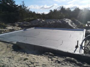 Isoleret husfundament under opførelse i sandet terræn