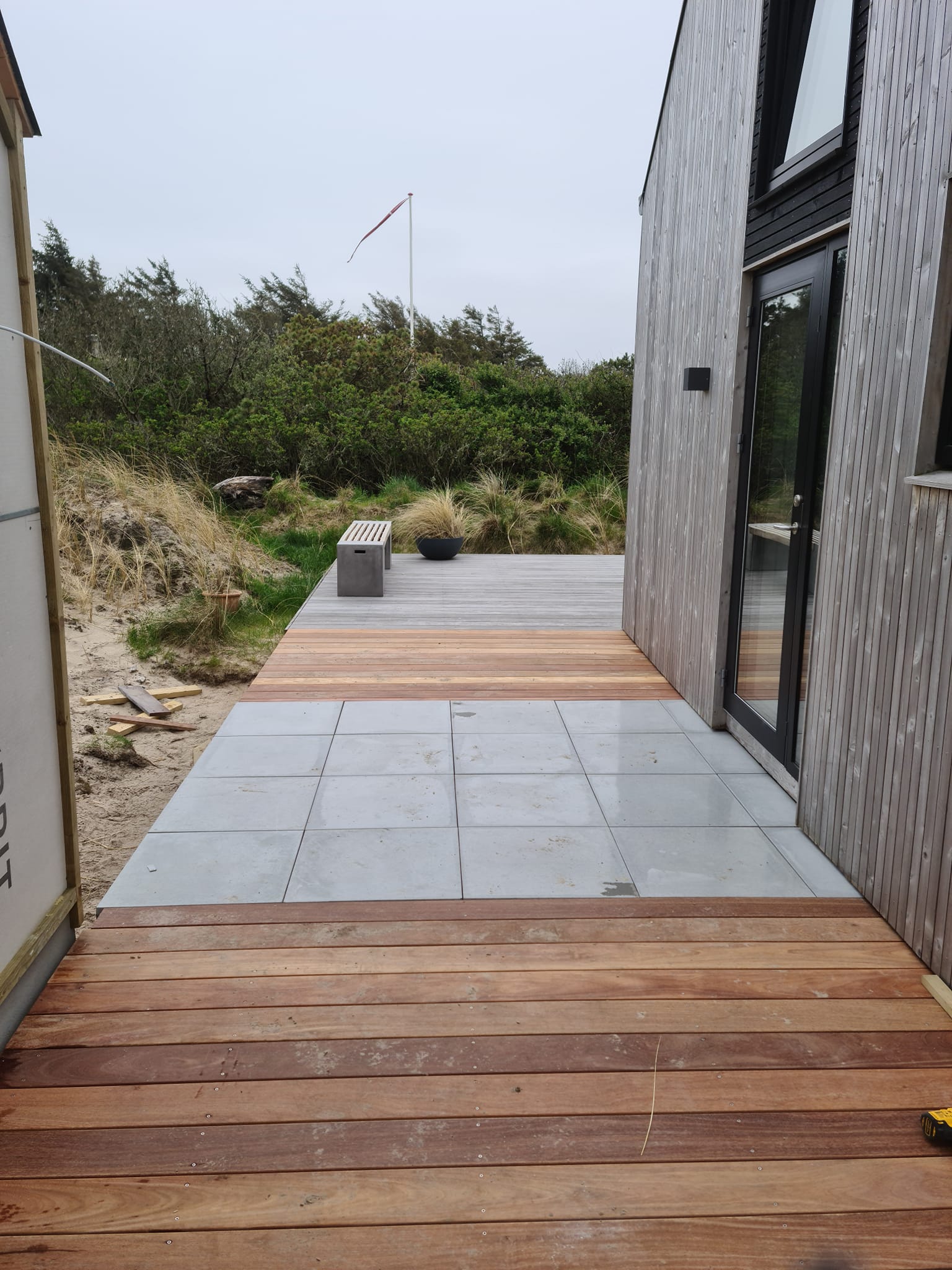 Træterrasse ved moderne sommerhus i klitlandskab