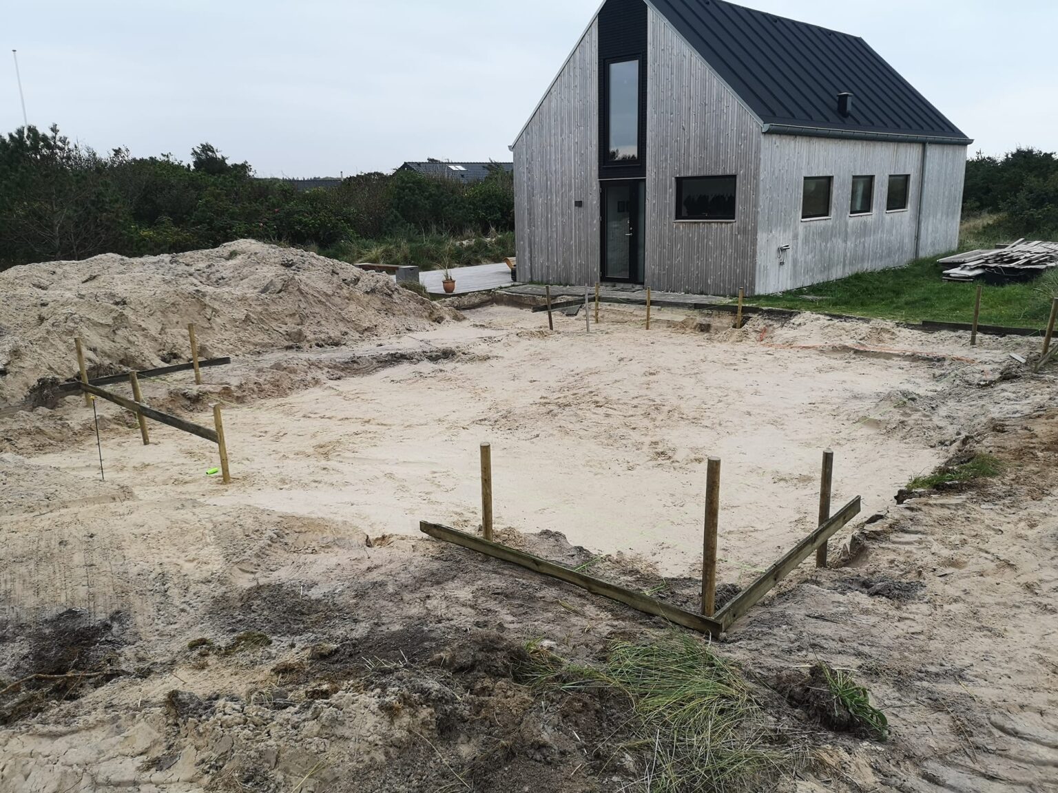 Byggegrund ved moderne træhus under opførelse